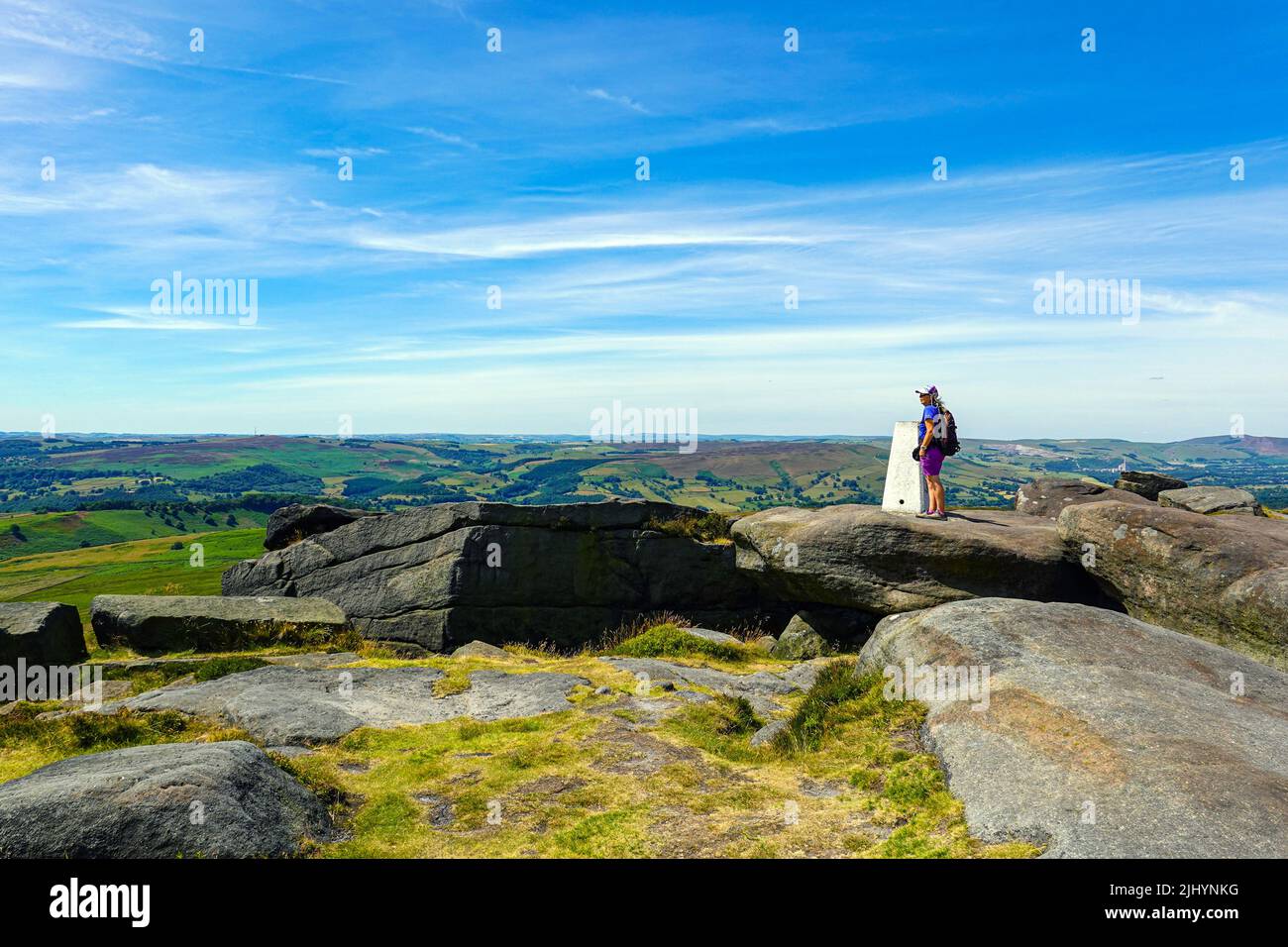 Escursionista femminile a Stanage Edge, Gritstone Cliff, Peak District National Park, Derbyshire, Regno Unito Foto Stock