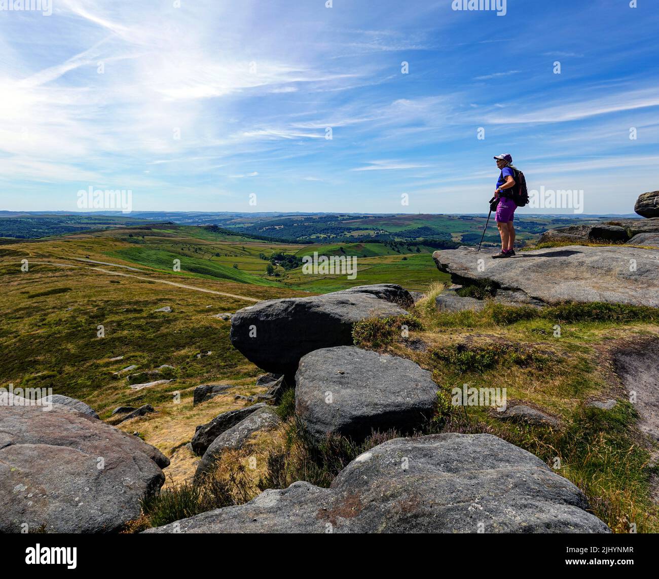 Escursionista femminile a Stanage Edge, Gritstone Cliff, Peak District National Park, Derbyshire, Regno Unito Foto Stock