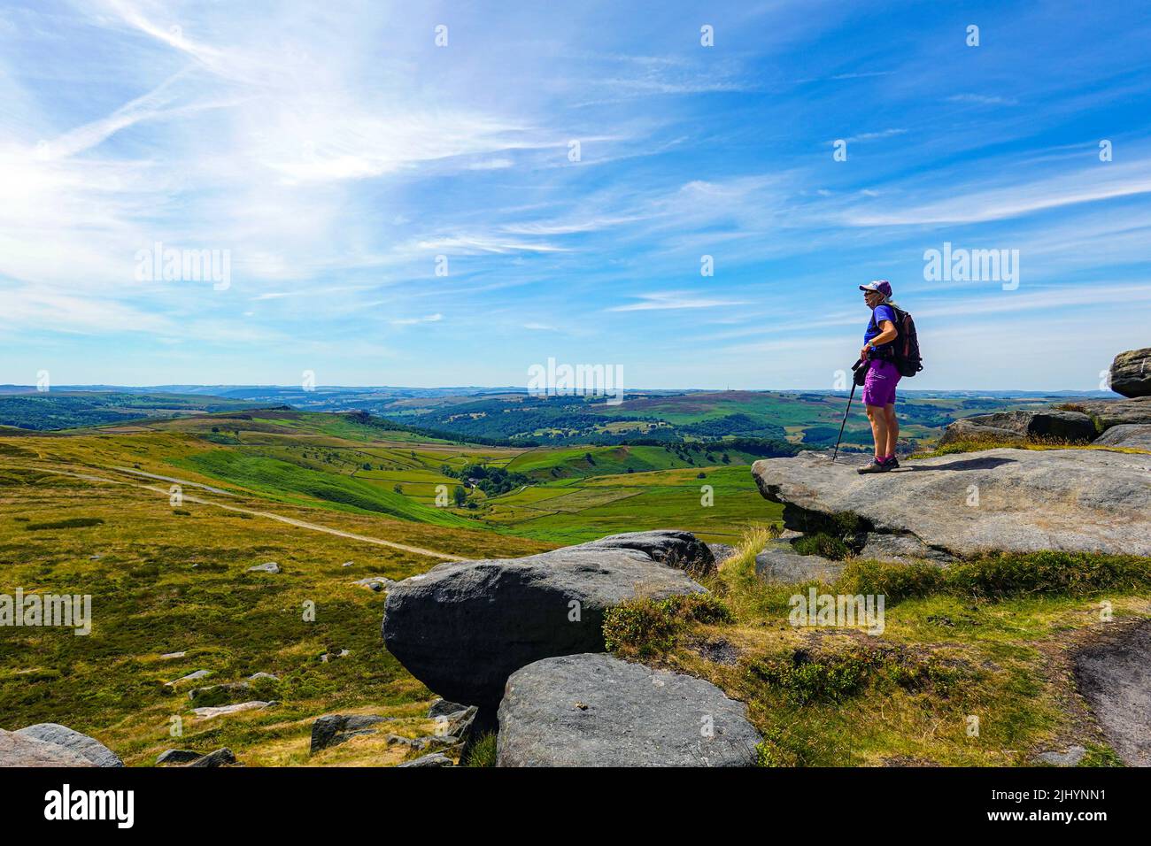 Escursionista femminile a Stanage Edge, Gritstone Cliff, Peak District National Park, Derbyshire, Regno Unito Foto Stock