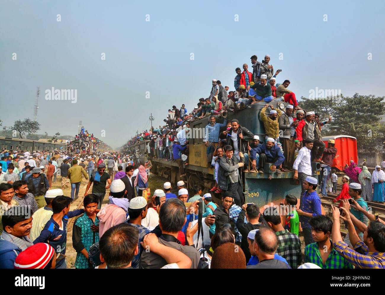 Migliaia di persone viaggiano sui tetti dei treni durante Ijtema in Bangladesh, mostrando un massiccio movimento umano, raduno islamico, fretta, caos di viaggio, religione, folla Foto Stock
