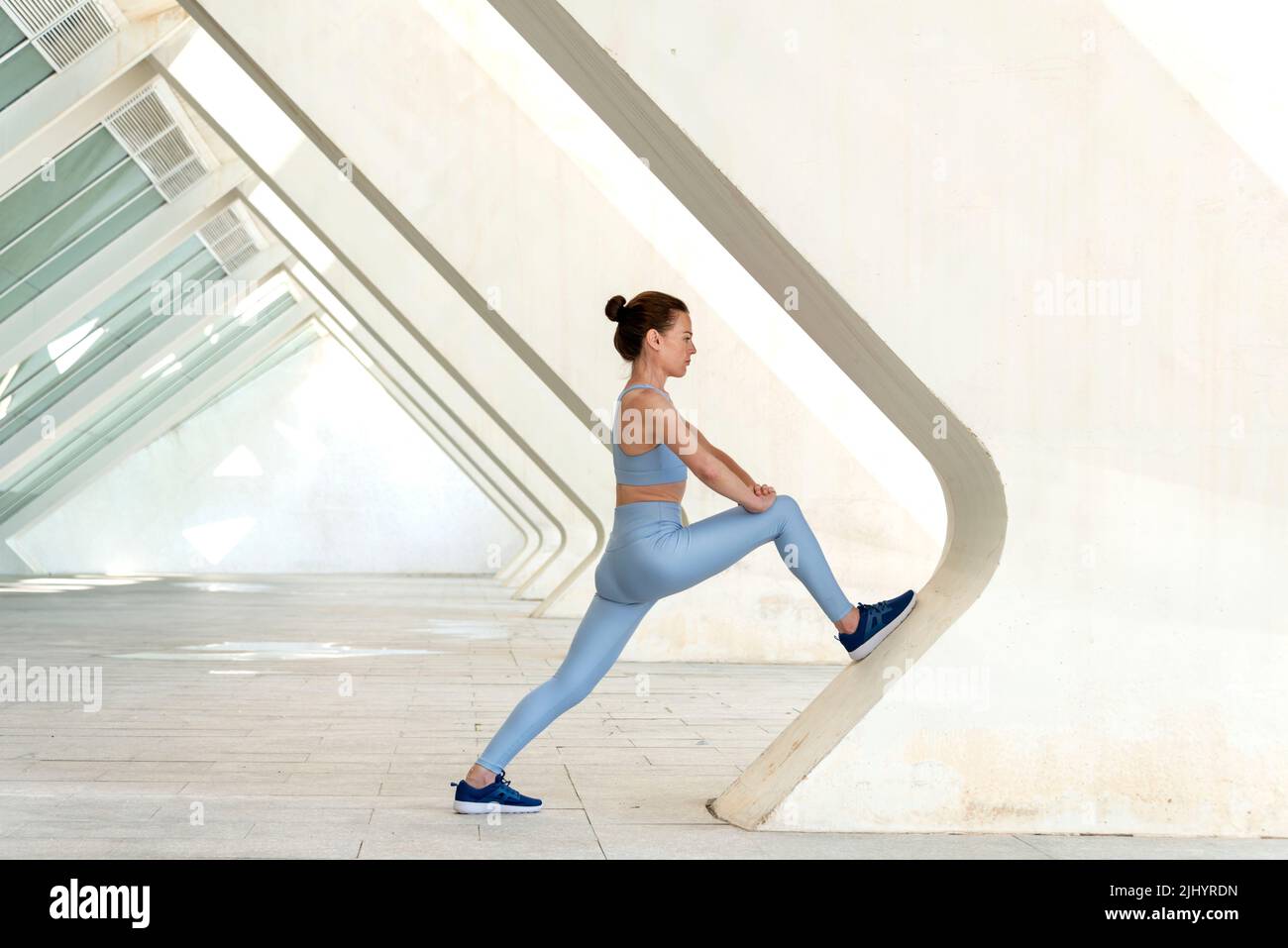 Donna sportiva che fa una gamba stretch riscaldamento esercizio. Foto Stock