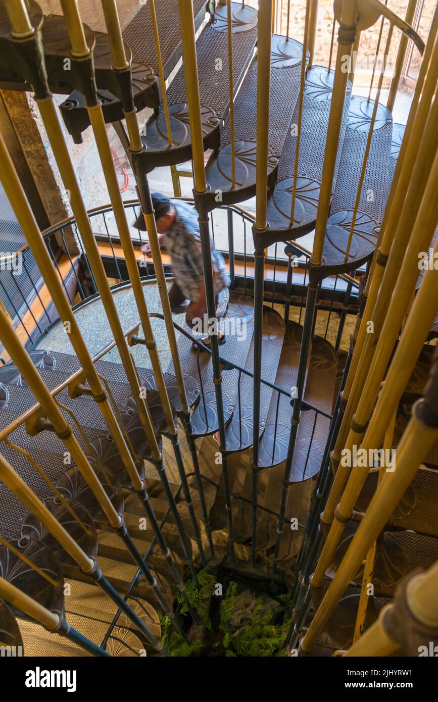 Scala a chiocciola in metallo art nouveau nel Castello di Lubiana. Slovenia. Una persona maschile sfocata ascendente Foto Stock