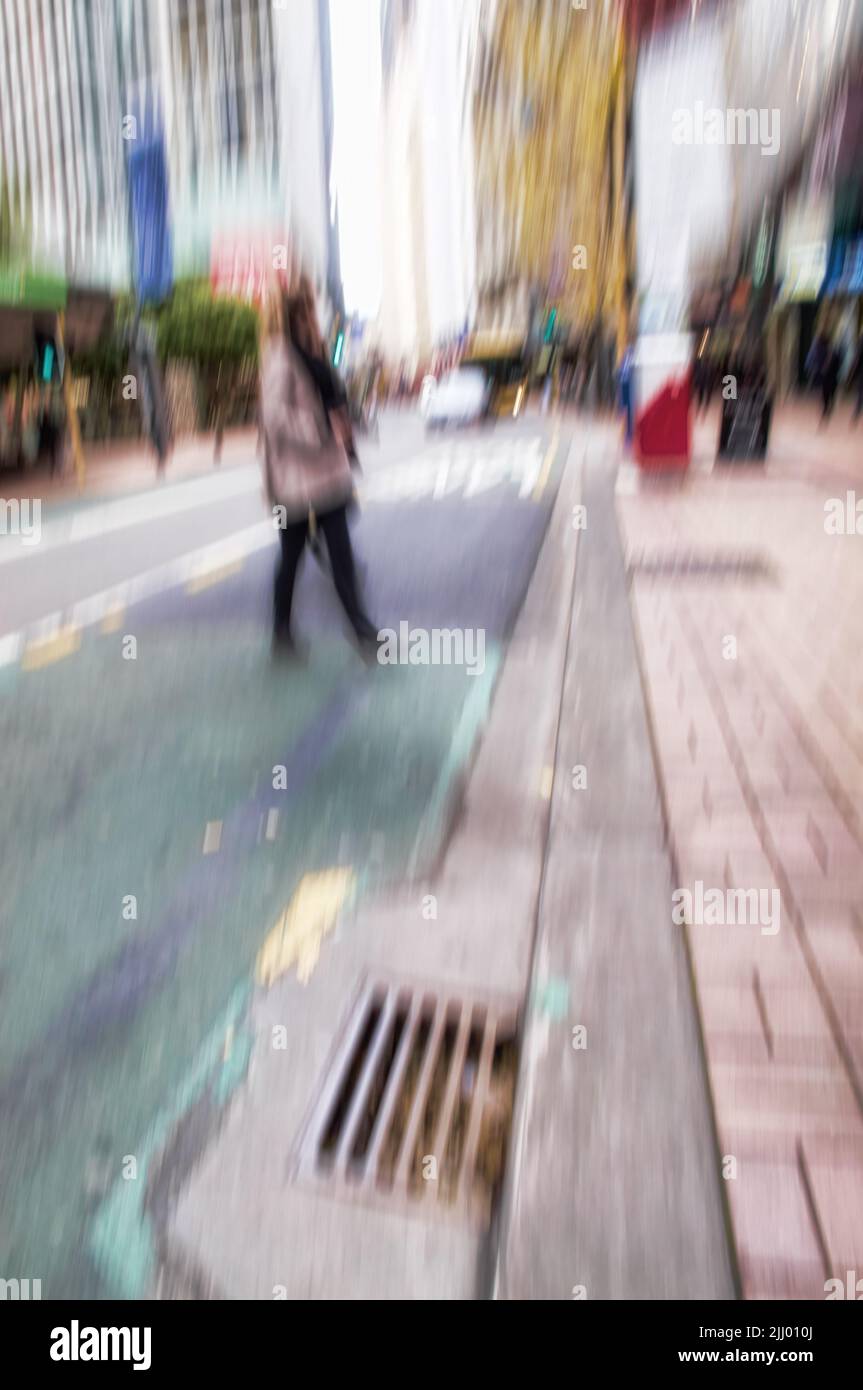 Stranieri sul loro viaggio in centro in una città. Strade trafficate con un attraversamento pedonale in movimento blurry a Manhattan, New York. Gente che cammina intorno Foto Stock