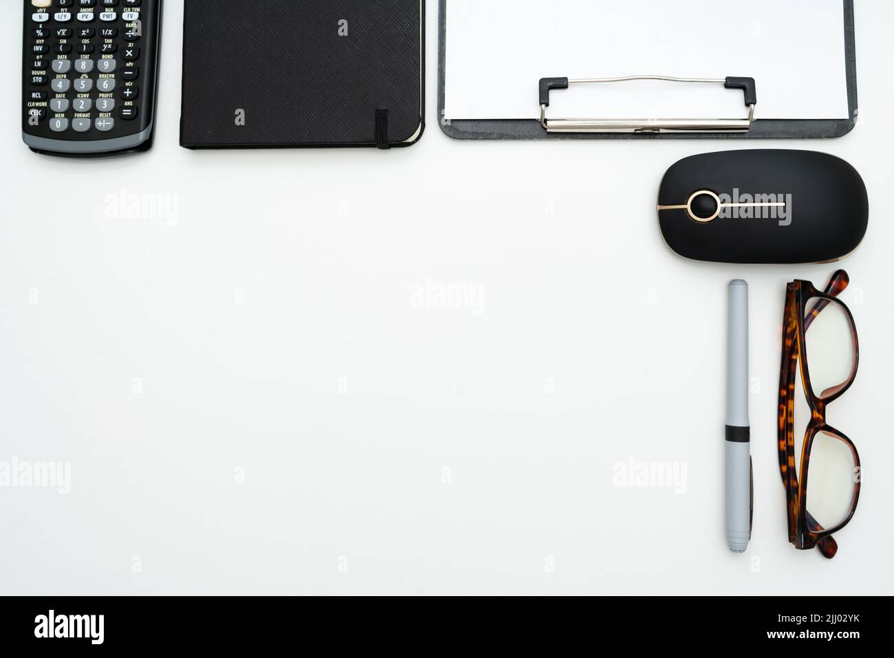Primo piano di un'area di lavoro con una calcolatrice, un mouse per computer e altre cancellerie, spazio di copia al centro Foto Stock