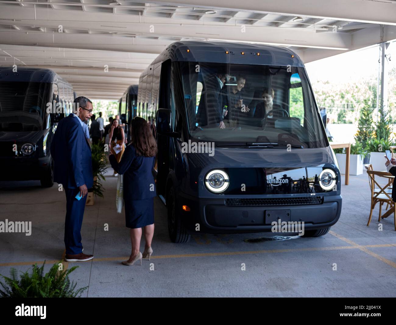 La gente si trova vicino al nuovo furgone Amazon EV alimentato da Rivian  parcheggiato presso l'Amazon Logistics Facility di Chicago. Amazon e Rivian  svelano i loro veicoli di consegna elettrica (EDV) personalizzati