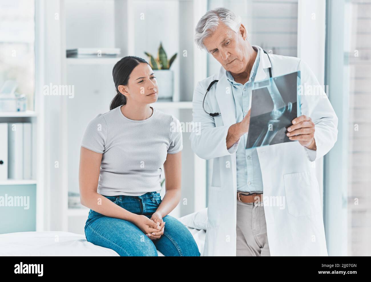 Hai fatto tre pause: Un medico e il suo paziente rivedono insieme i raggi X. Foto Stock