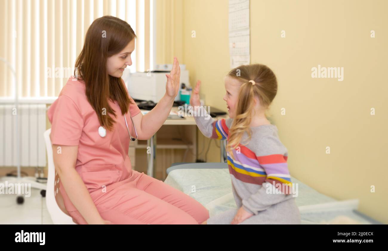 paziente di 4 anni con gioia alto fives per l'infermiere Foto Stock