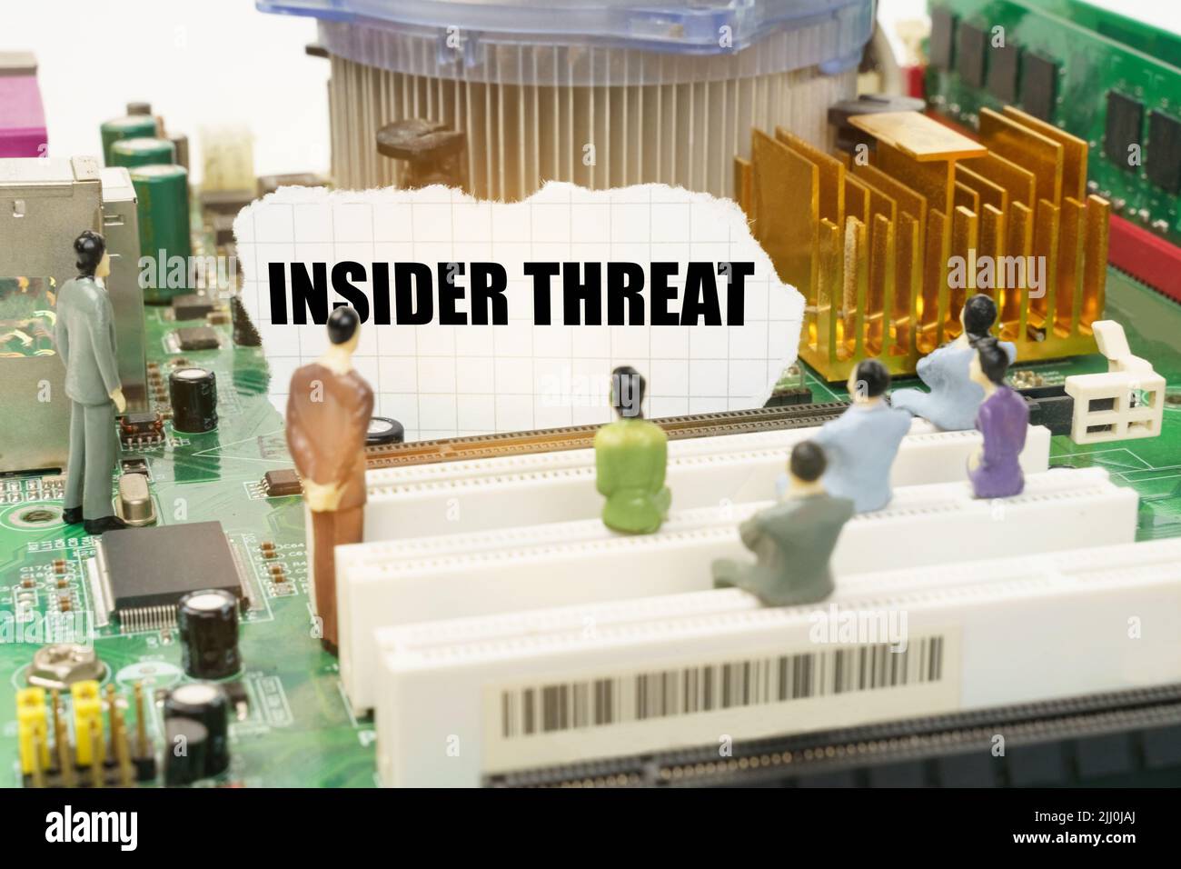 Tecnologia e concetto di computer. Sulla scheda madre ci sono figure di persone e carta strappata con l'iscrizione - Insider Threat Foto Stock