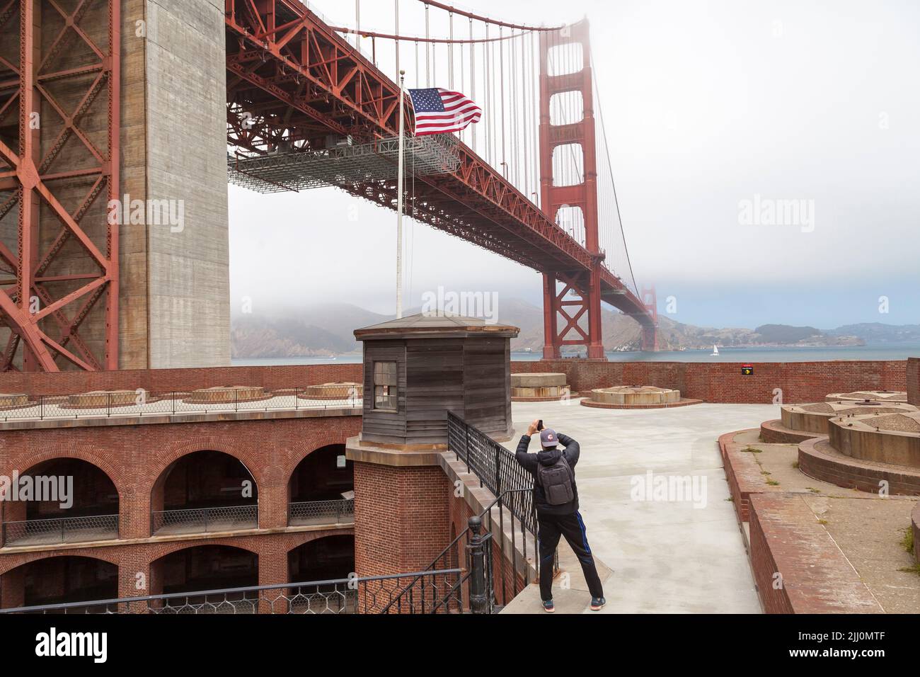 Uomo che scatta foto del Golden Gate Bridge dal tetto di Fort Point, San Francisco, California, USA Foto Stock