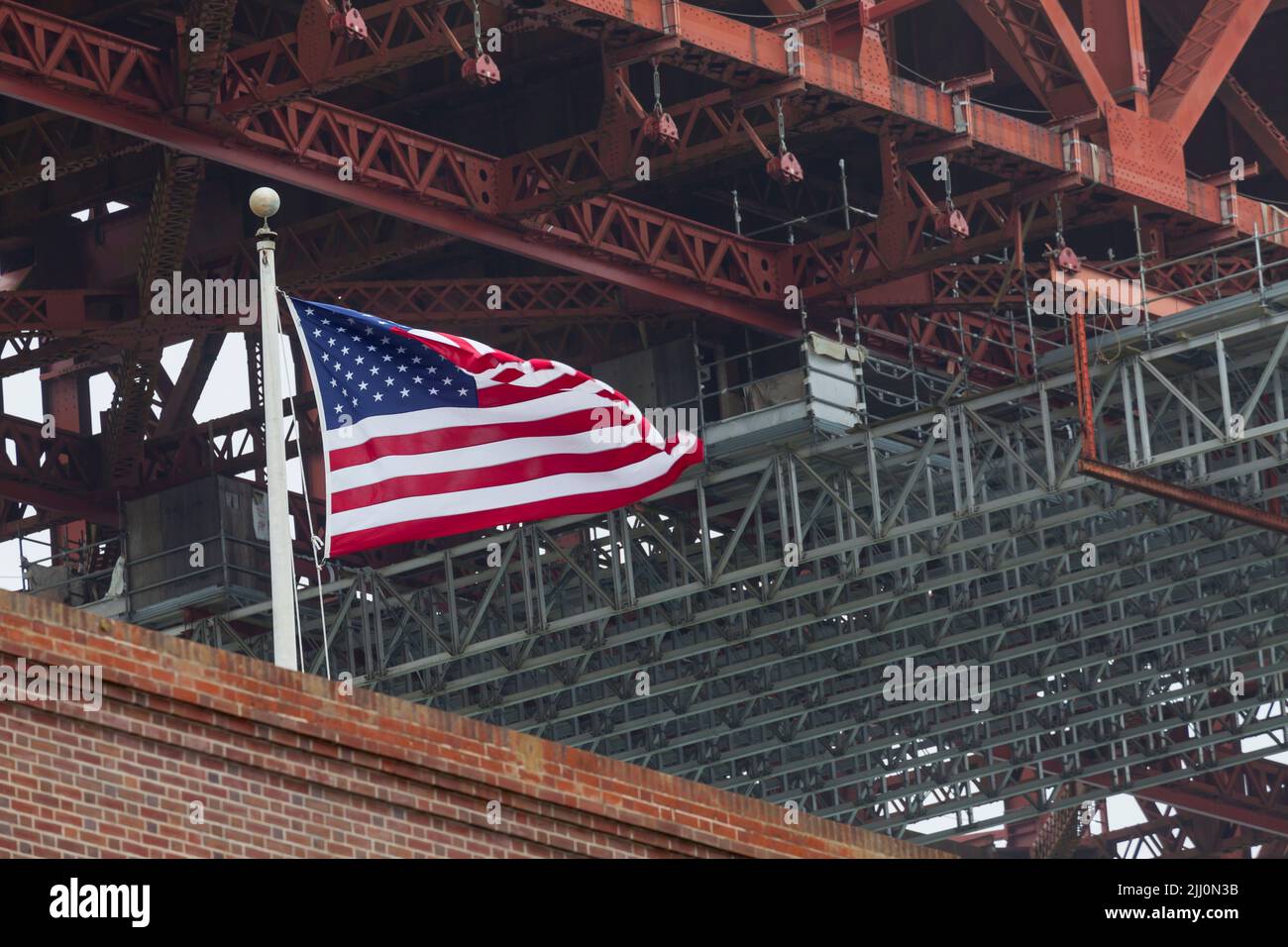 Bandiera americana in cima al Fort Point edificio sotto il Golden Gate Bridge, San Francisco, California, USA Foto Stock
