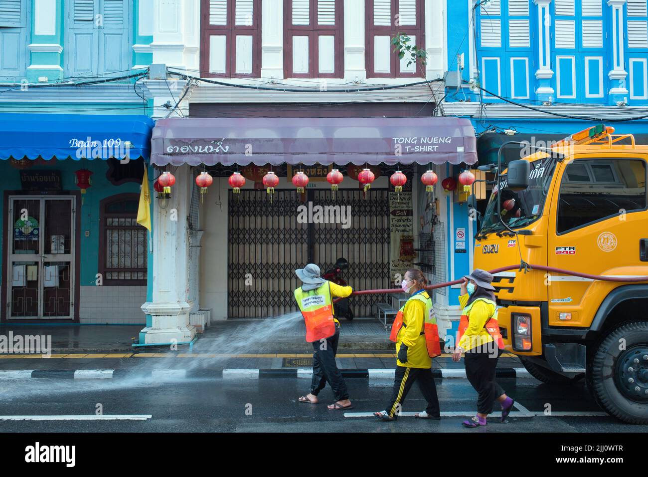 Al mattino presto, i lavoratori municipali puliscono Thalang Road nella zona della città vecchia di Phuket, Thailandia, le sue case sino-portoghesi un'attrazione turistica Foto Stock