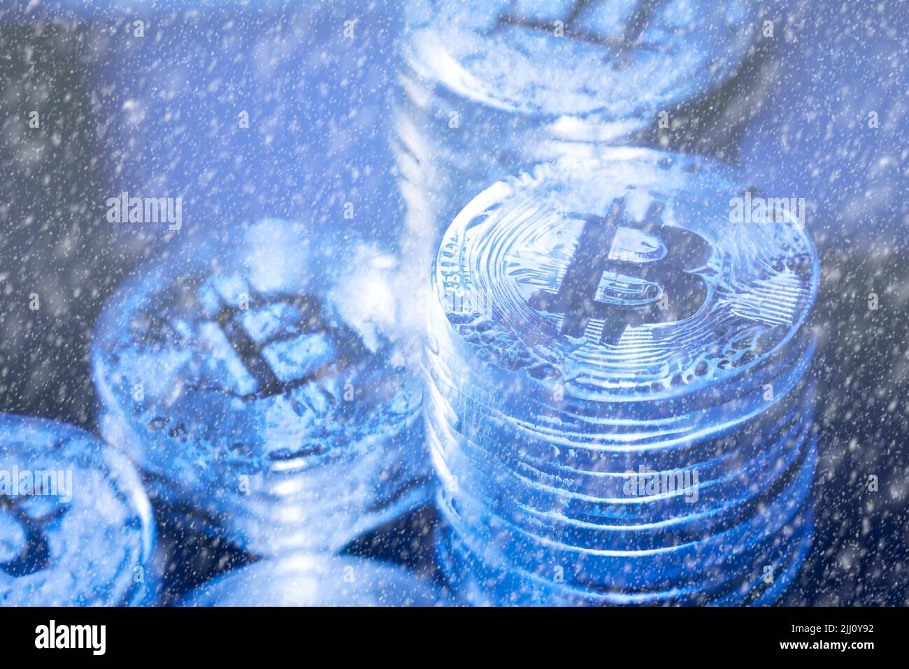 Concetto per Crypto inverno, Bitcoin in ghiaccio blu. Crollo del prezzo dei Bitcoin. Vista orizzontale dei token di criptovaluta, tra cui Bitcoin, Ethererum Ripple e Litecoin visto dall'alto su sfondo blu lucido texture Foto Stock