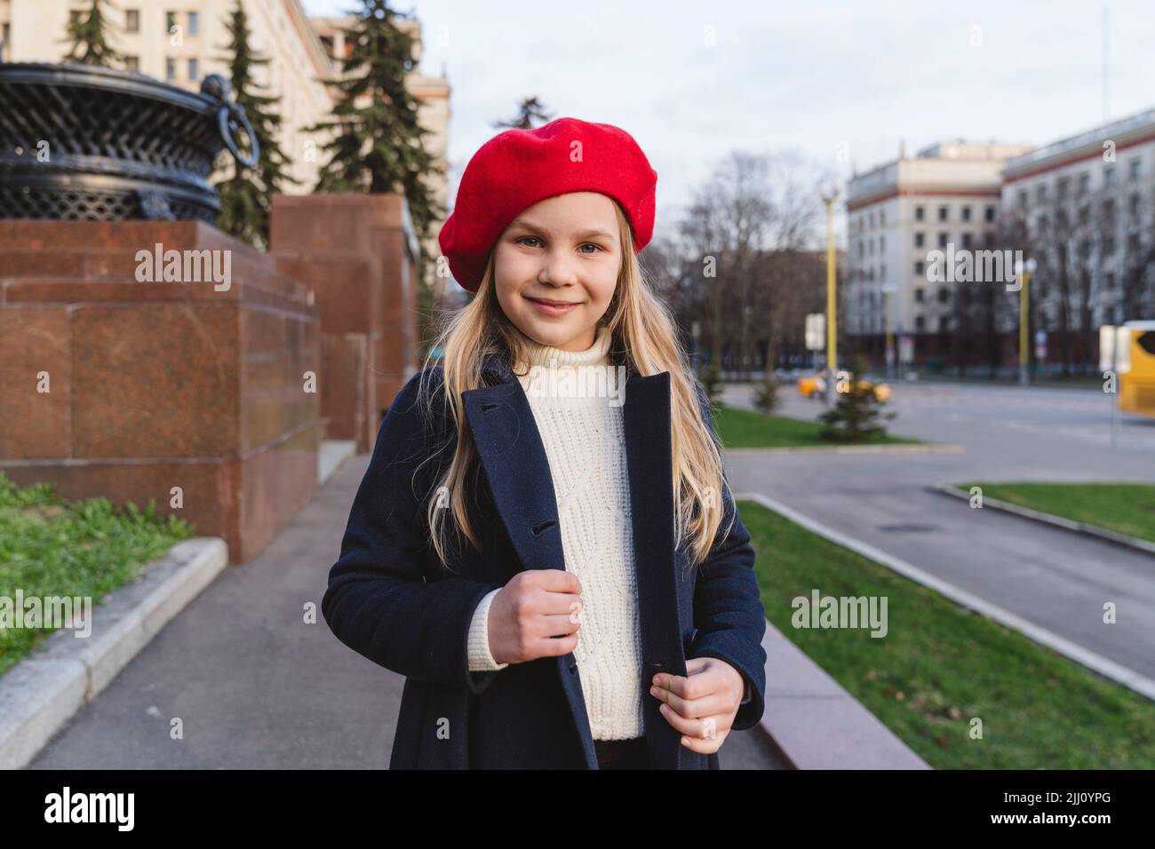Ritratto di una ragazza carina in un cappotto e un berretto rosso. Foto Stock