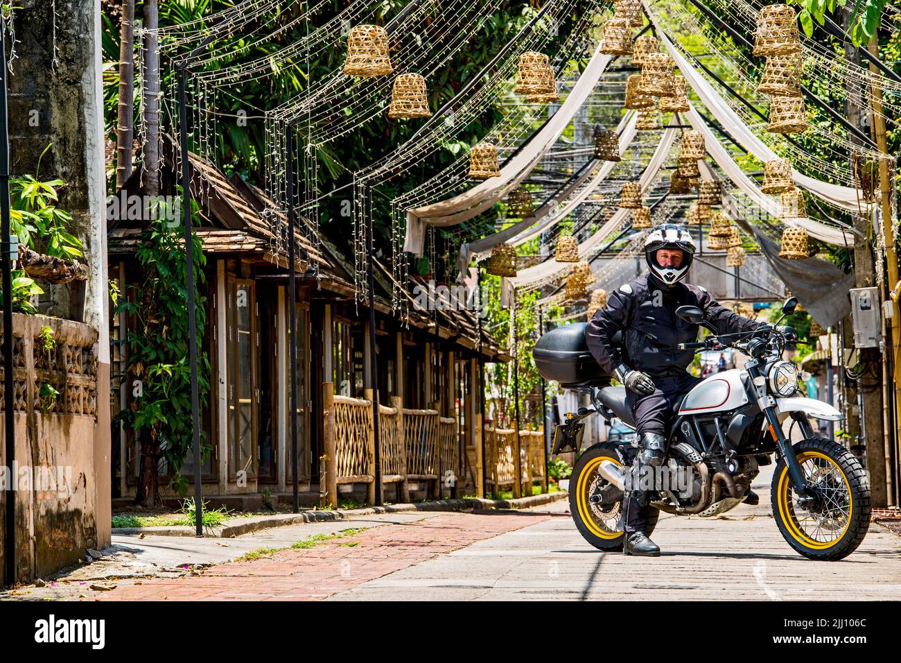 Uomo che guida la sua moto classica nel nord della Thailandia Foto Stock
