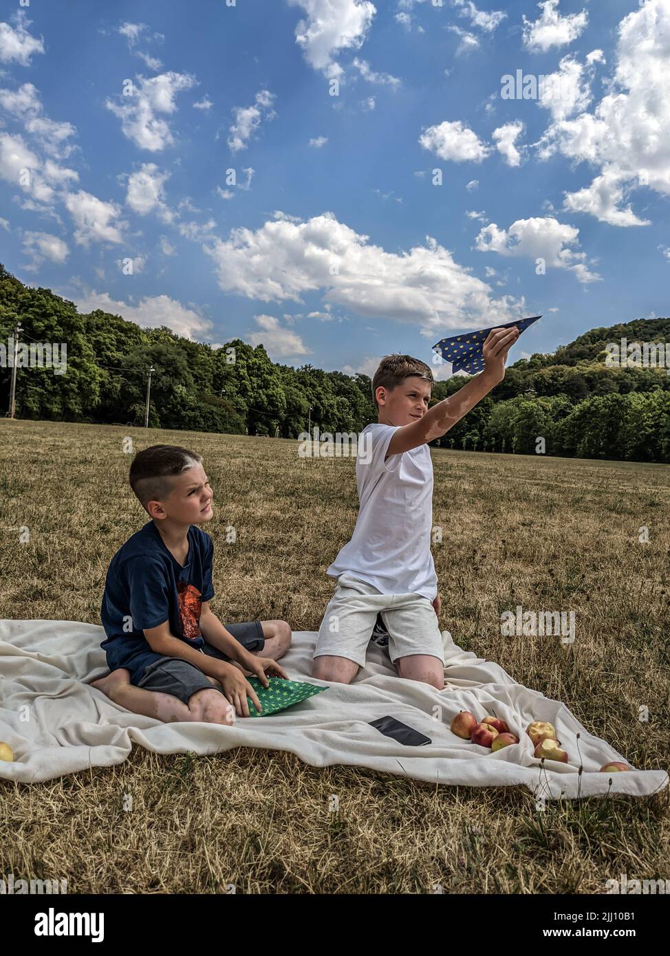 I ragazzi giocano aeroplani di carta, telefono, tempo libero Foto Stock
