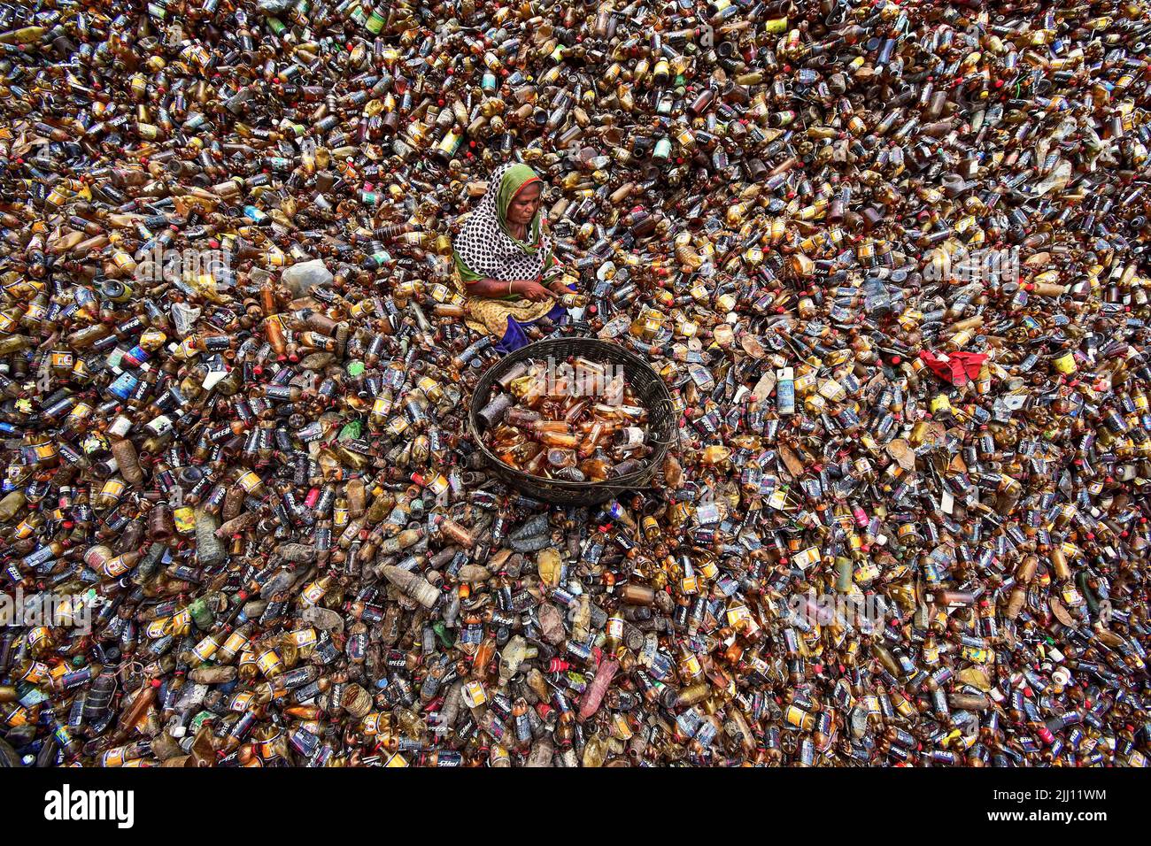 Lavoratori che selezionano a mano bottiglie di plastica in un impianto di riciclaggio, Bogura Bangladesh. Rifiuti di plastica, riutilizzo, industria verde, manodopera, pulizia, sostenibilità Foto Stock