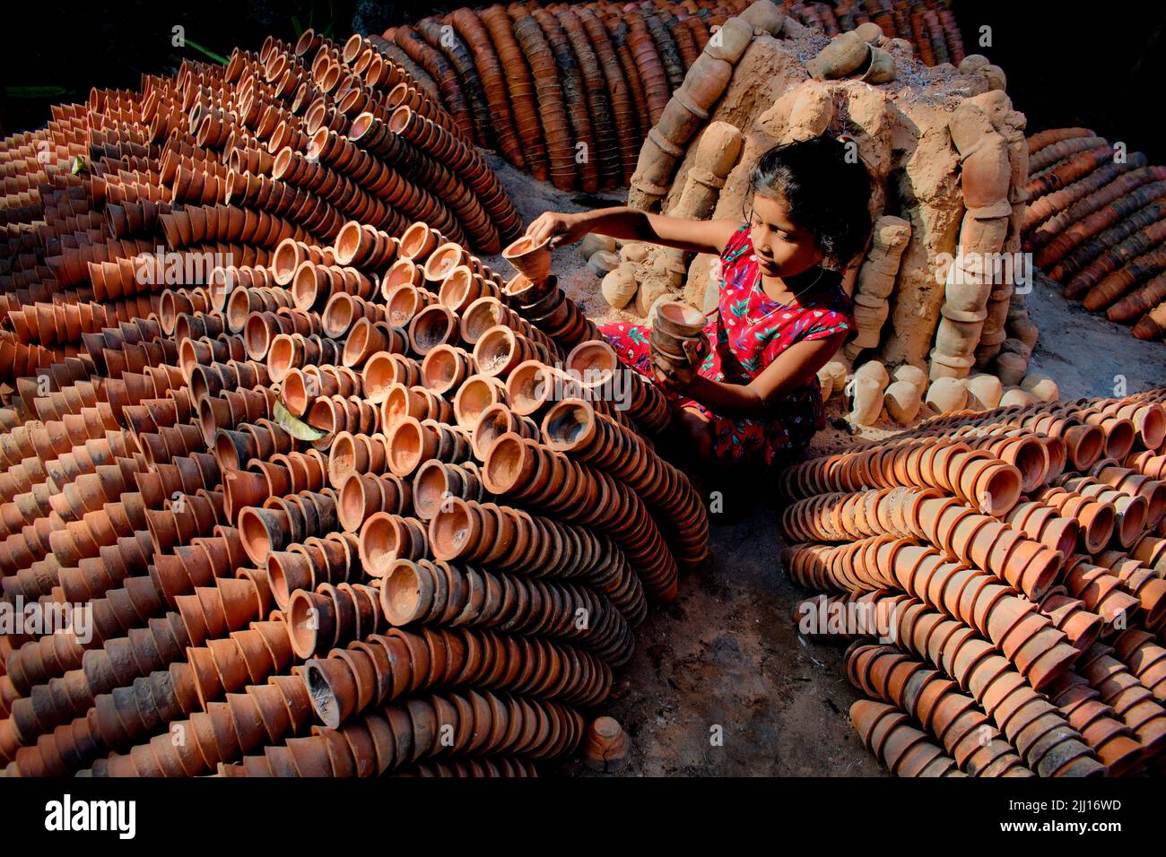 Ceramiche che filano l'argilla a mano nel Bangladesh rurale, mostrando la vita del villaggio, i toni della terra, la produzione tradizionale di ceramiche, artigianato artigianale, cultura locale Foto Stock