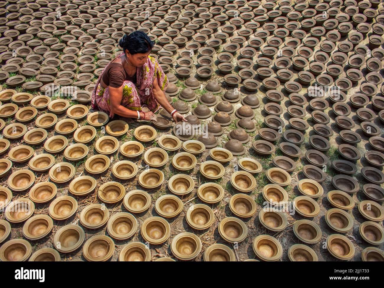 Ceramiche che filano l'argilla a mano nel Bangladesh rurale, mostrando la vita del villaggio, i toni della terra, la produzione tradizionale di ceramiche, artigianato artigianale, cultura locale Foto Stock