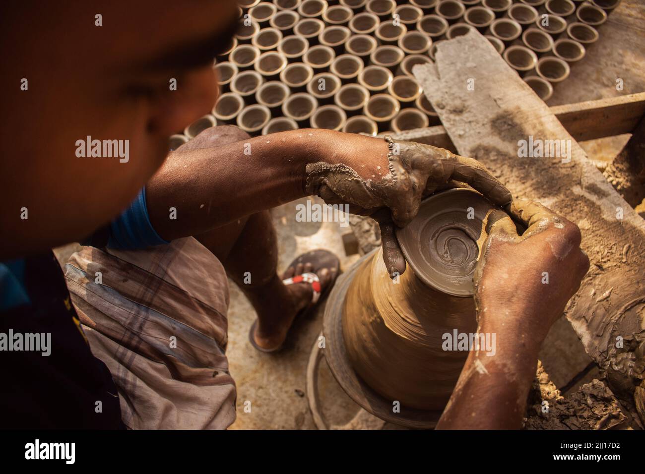 Ceramiche che filano l'argilla a mano nel Bangladesh rurale, mostrando la vita del villaggio, i toni della terra, la produzione tradizionale di ceramiche, artigianato artigianale, cultura locale Foto Stock