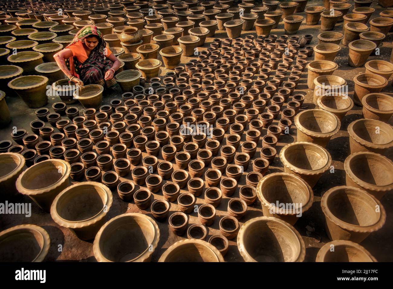 Ceramiche che filano l'argilla a mano nel Bangladesh rurale, mostrando la vita del villaggio, i toni della terra, la produzione tradizionale di ceramiche, artigianato artigianale, cultura locale Foto Stock