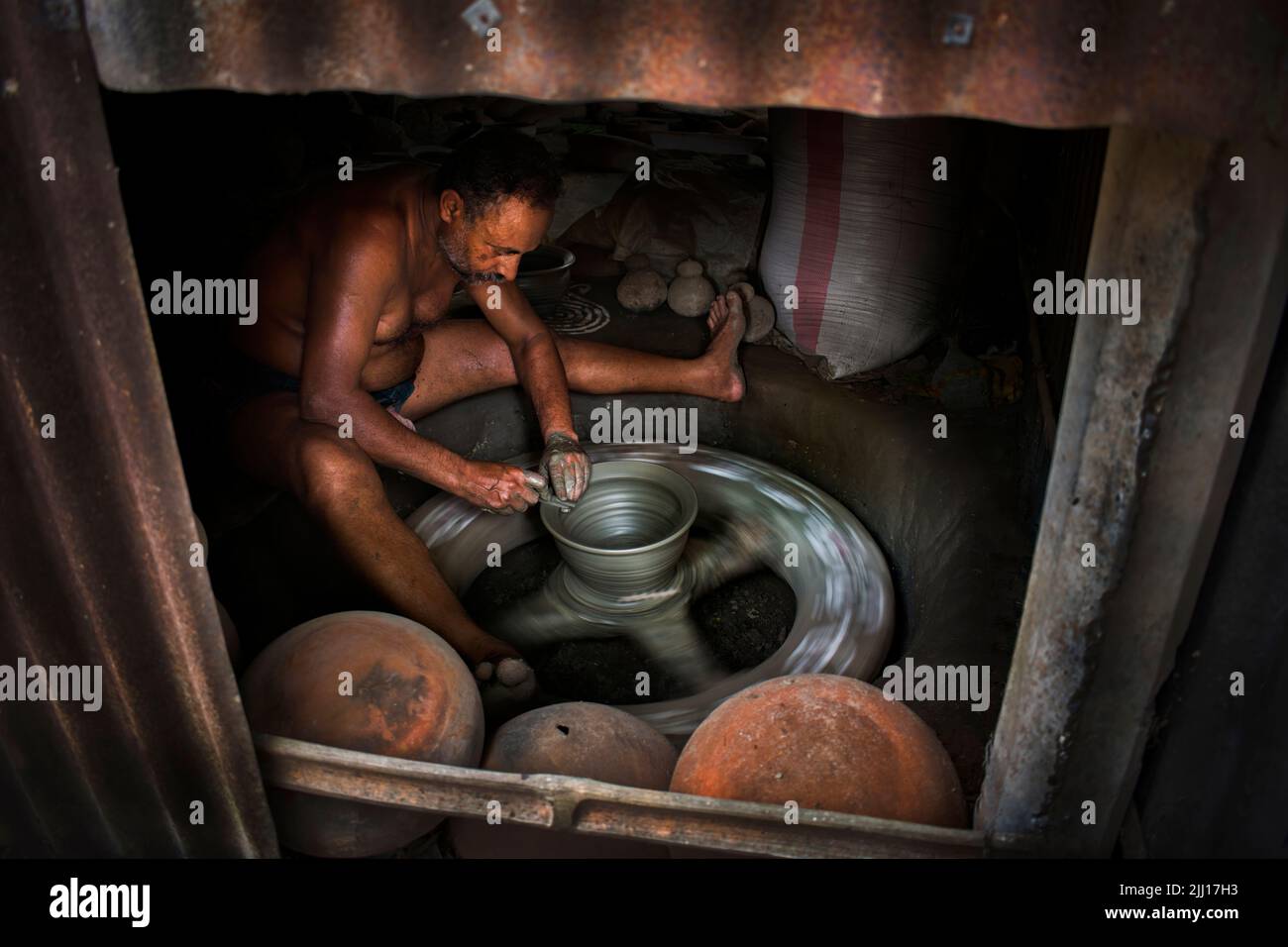 Ceramiche che filano l'argilla a mano nel Bangladesh rurale, mostrando la vita del villaggio, i toni della terra, la produzione tradizionale di ceramiche, artigianato artigianale, cultura locale Foto Stock