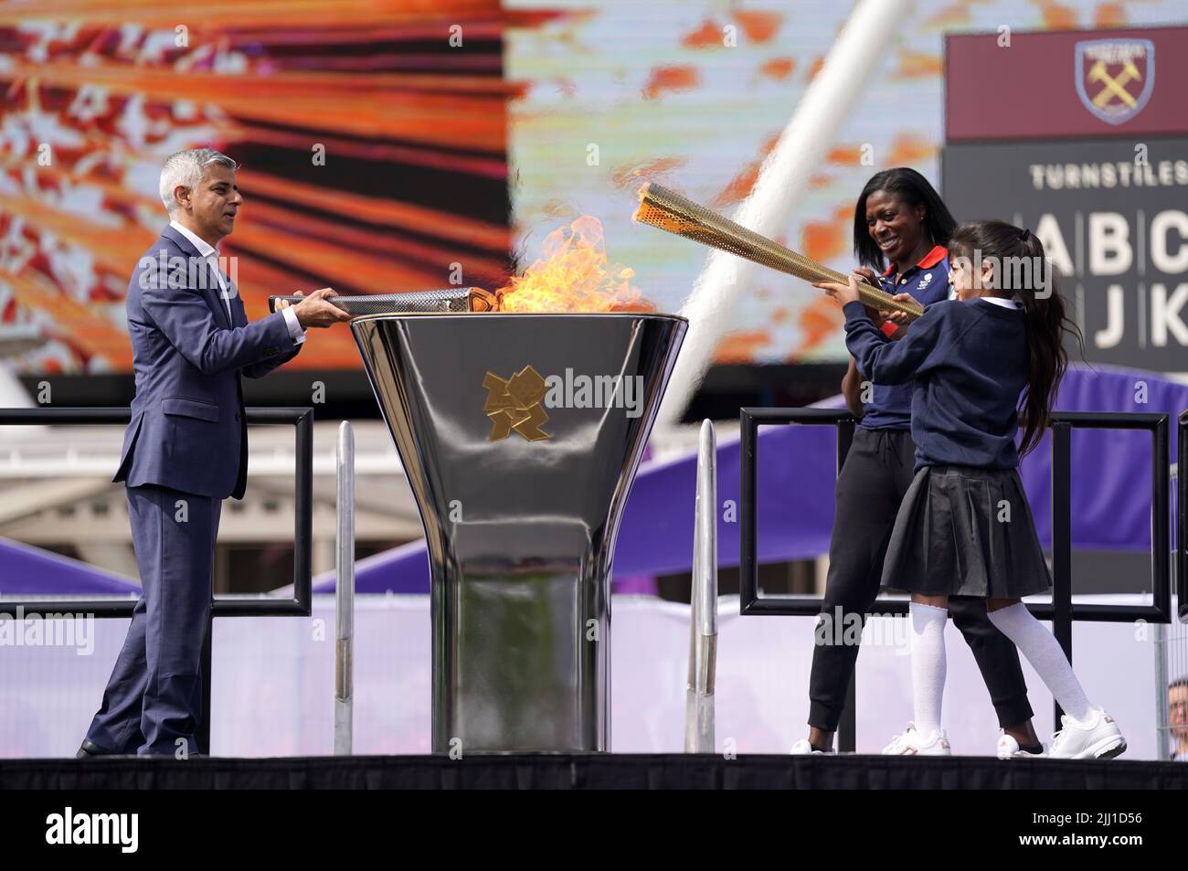 Il sindaco di Londra Sadiq Khan (a sinistra) e i medalisti d'oro olimpici Christine Ohuruogu (al centro) aiutano a illuminare la fiamma Legacy durante l'evento di 10th anni delle Olimpiadi di Londra del 2012 che si tiene al Bridge uno al Queen Elizabeth Olympic Park di Londra. Mercoledì 27 luglio segnerà esattamente 10 anni dalla cerimonia di apertura dei Giochi Olimpici di Londra 2012. Data foto: Venerdì 22 luglio 2022. Foto Stock