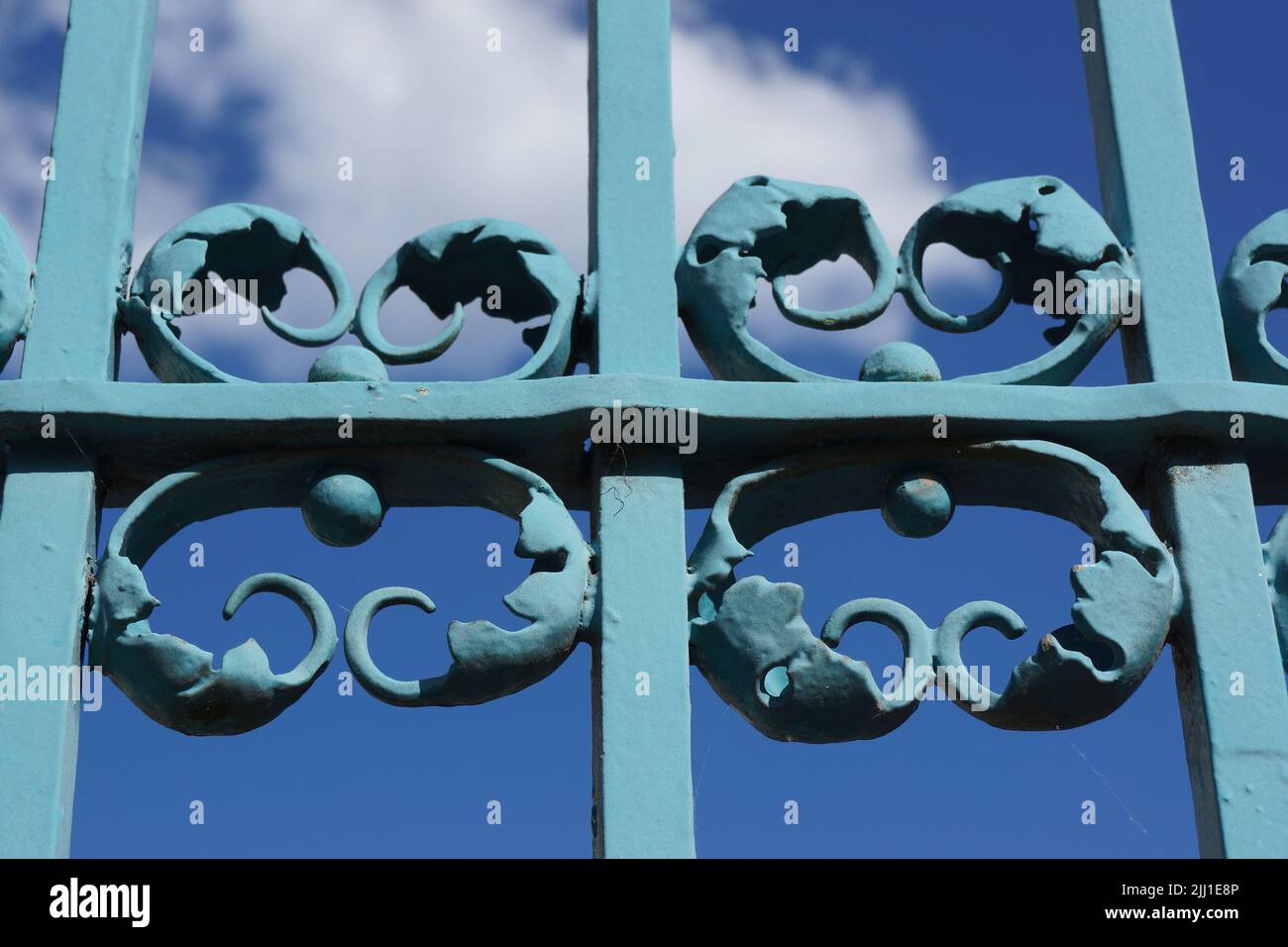 Dettagli del cancello in ferro battuto al castello di Bad Homburg contro il cielo blu. Un'opera d'arte spesso dipinta sopra. Bel gioco di colori e ombre. Foto Stock