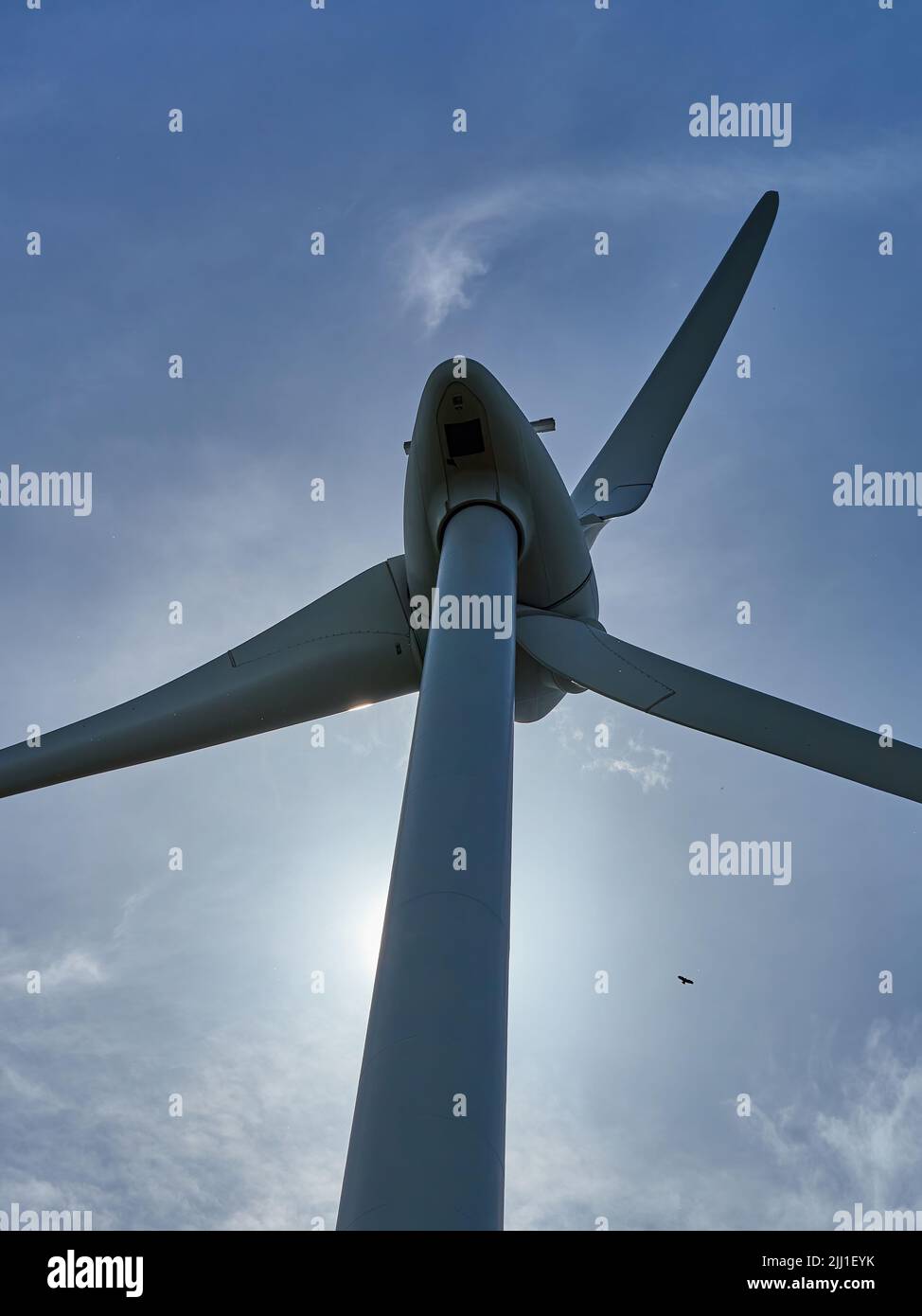 Una grande turbina eolica a Marston Moretaine, contro un cielo blu estivo con nuvole di lana di cotone, con un lontano aquilone rosso in volo. Foto Stock