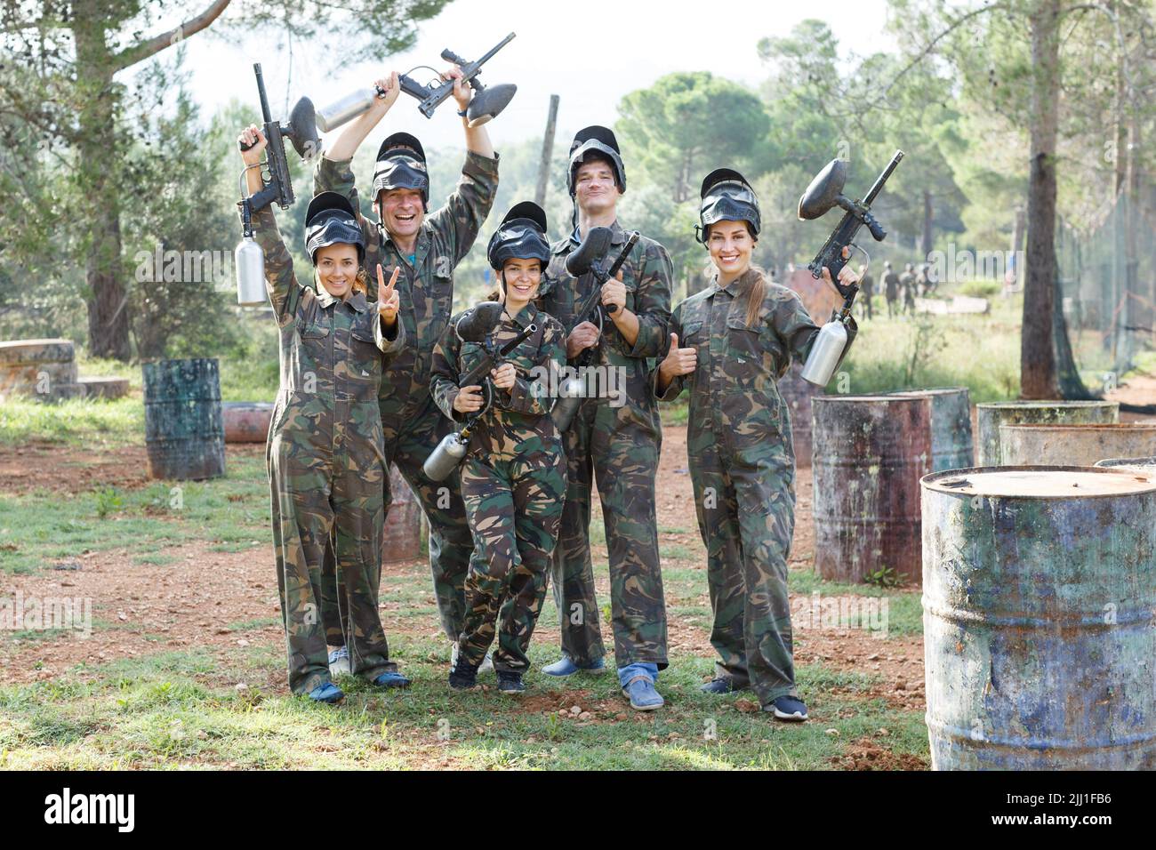 Gruppo amichevole di giocatori di paintball in camouflage in piedi con pistole sul paintball giocare Foto Stock