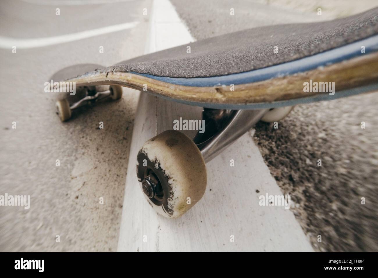 Primo piano dello skateboard in movimento sulla segnaletica stradale della città Foto Stock