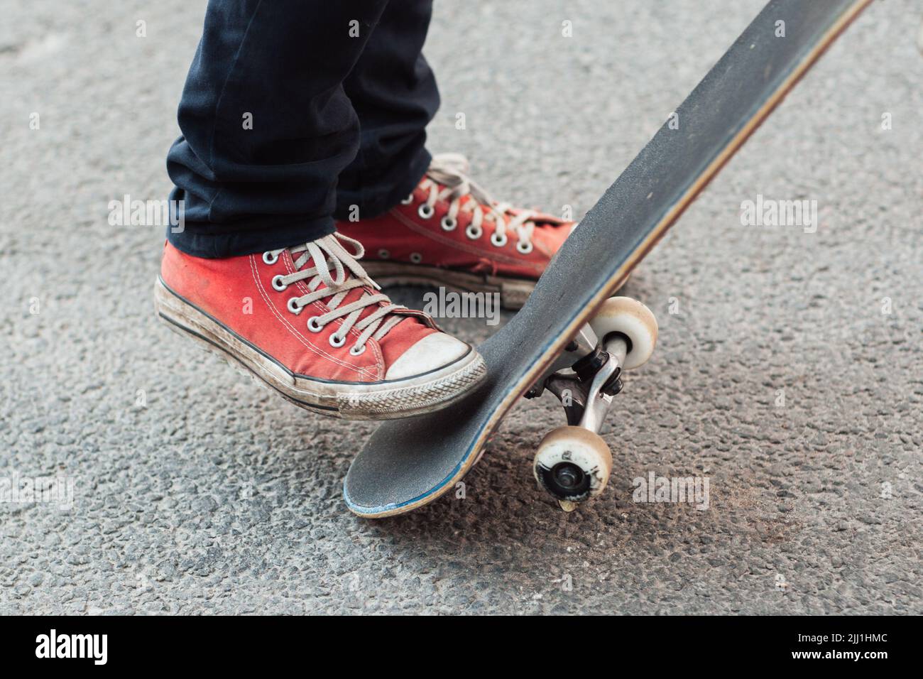 Skater che fa il trucco con la coda dello skateboard Foto Stock