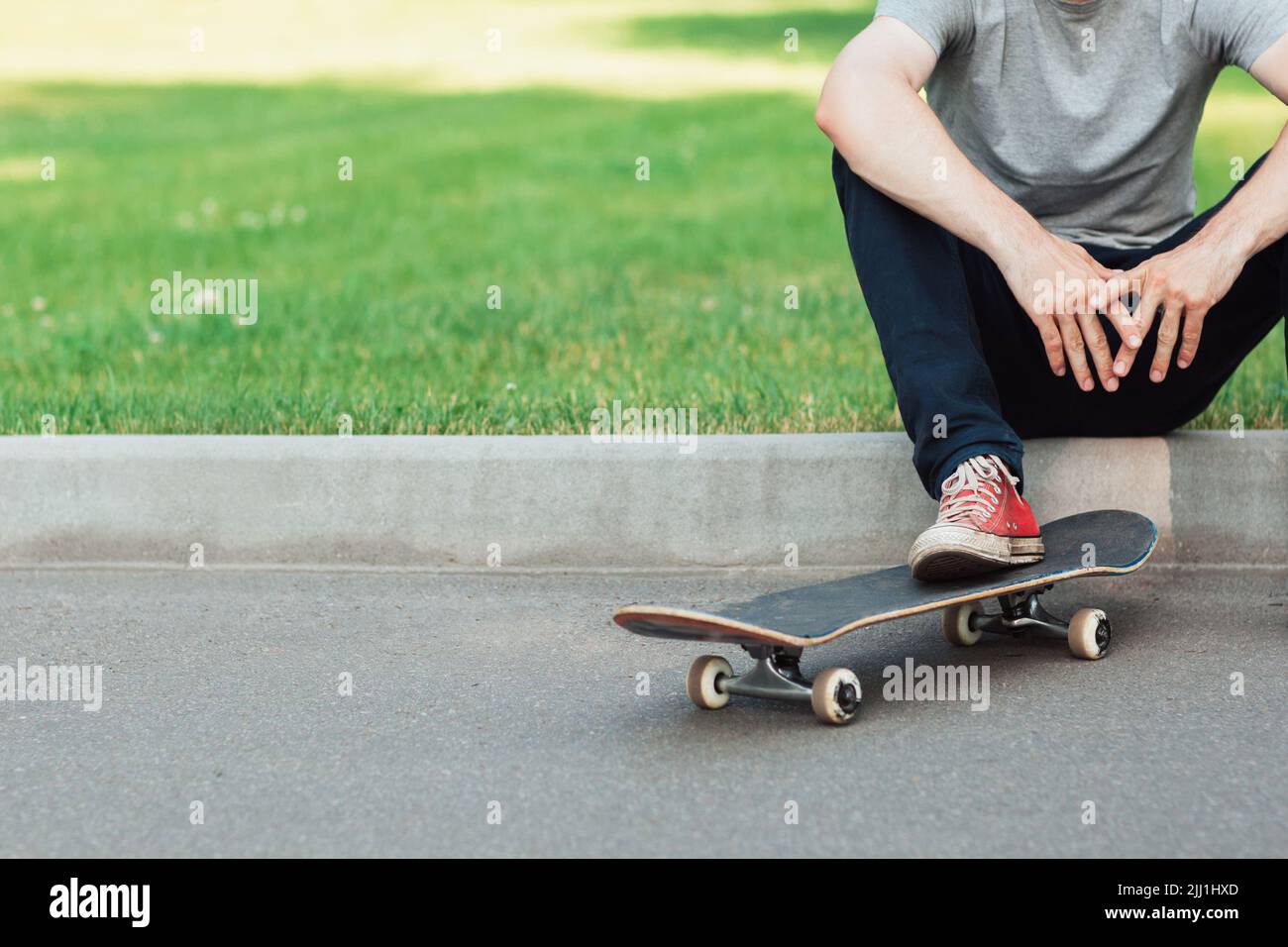 Un hipster uomo irriconoscibile con skateboard Foto Stock