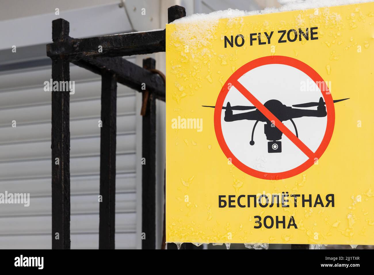 No fly zone, segno di divieto con testo russo e inglese su sfondo giallo Foto Stock