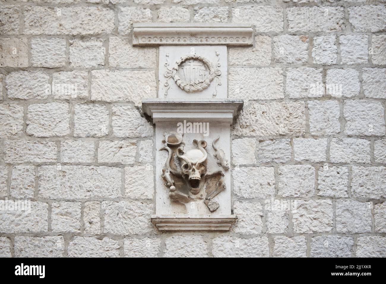 Figura di un teschio su un muro di pietra di un edificio. Foto Stock