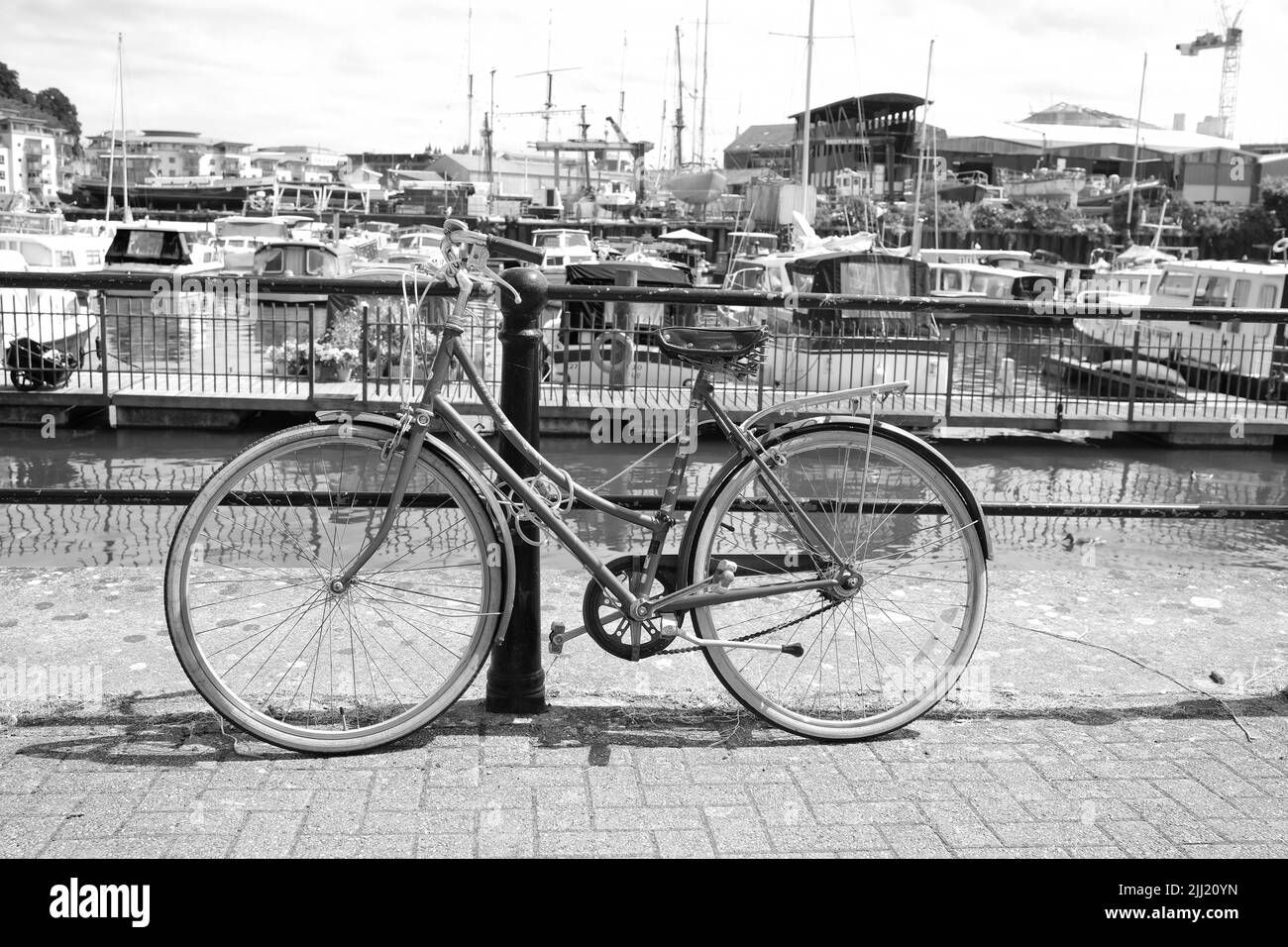 2022 luglio - ben usato donna bici fissa securey a una rotaia di sicurezza sul porto a Bristol, Inghilterra, Regno Unito, Foto Stock