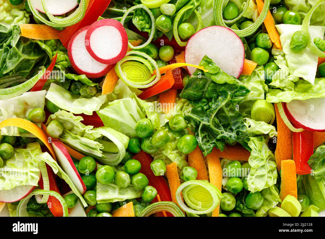Insalata verde vegetariana fresca con cavolo di savoia, carota cruda, ravanello, peperone, porro e piselli verdi Foto Stock