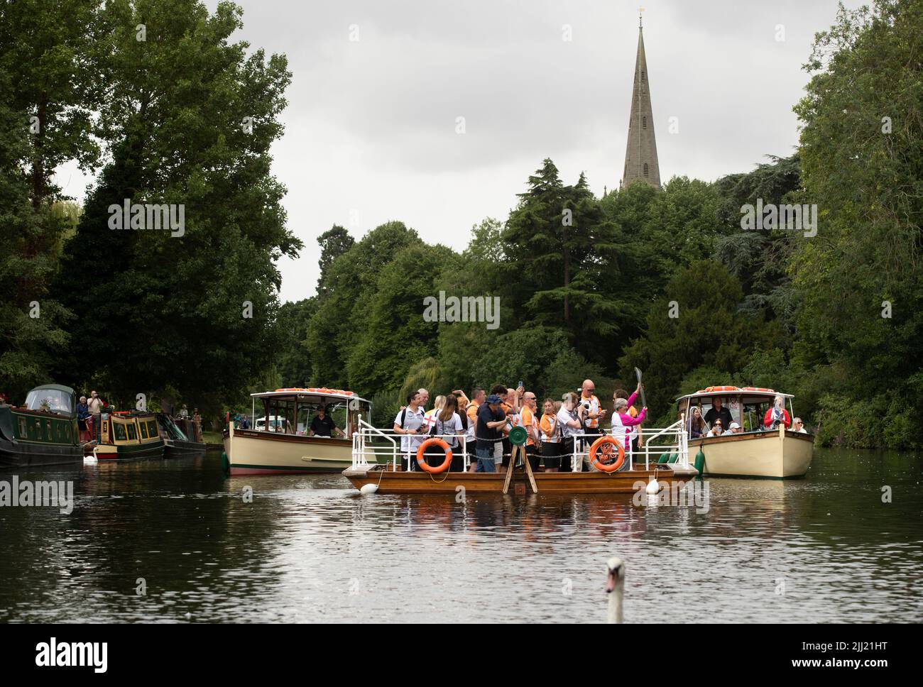 Stratford upon Avon, Regno Unito. 22nd luglio 2022. Un portatore di Baton porta la Baton della regina dei giochi del Commonwealth a bordo di un traghetto mentre attraversa il fiume Avon a Stratford upon Avon Warwickshire credito: Chris Radburn/Alamy Live News Foto Stock
