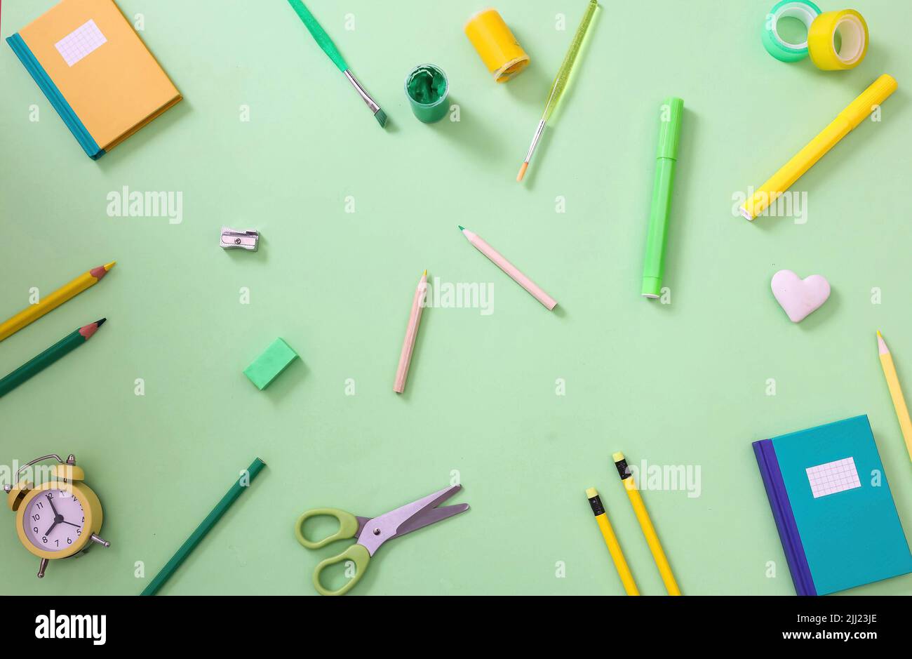 L'ufficio della scuola fornisce il background. Concetto di ritorno a scuola. Giallo pastello e verde cancelleria di colore piatto, vista dall'alto. Foto Stock