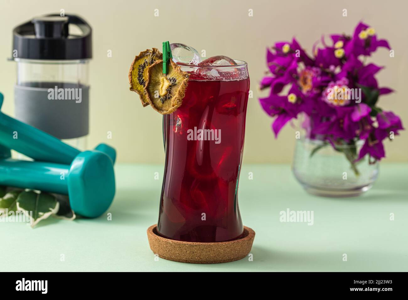 Rinfrescante bevanda salutare in una lunga tazza di vetro su sfondo verde chiaro Foto Stock