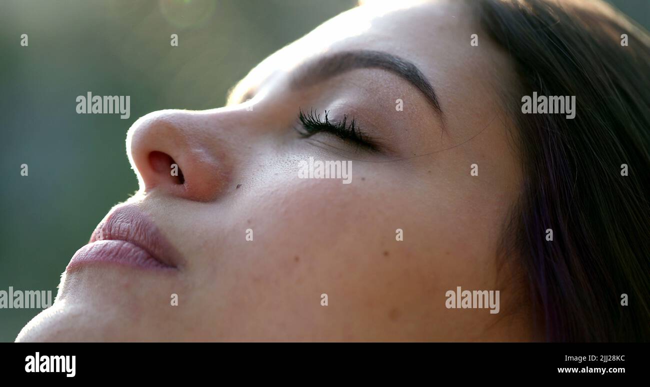 La giovane donna si affida agli occhi aperti nella meditazione e nella contemplazione che si stagliano al cielo con speranza e fede Foto Stock