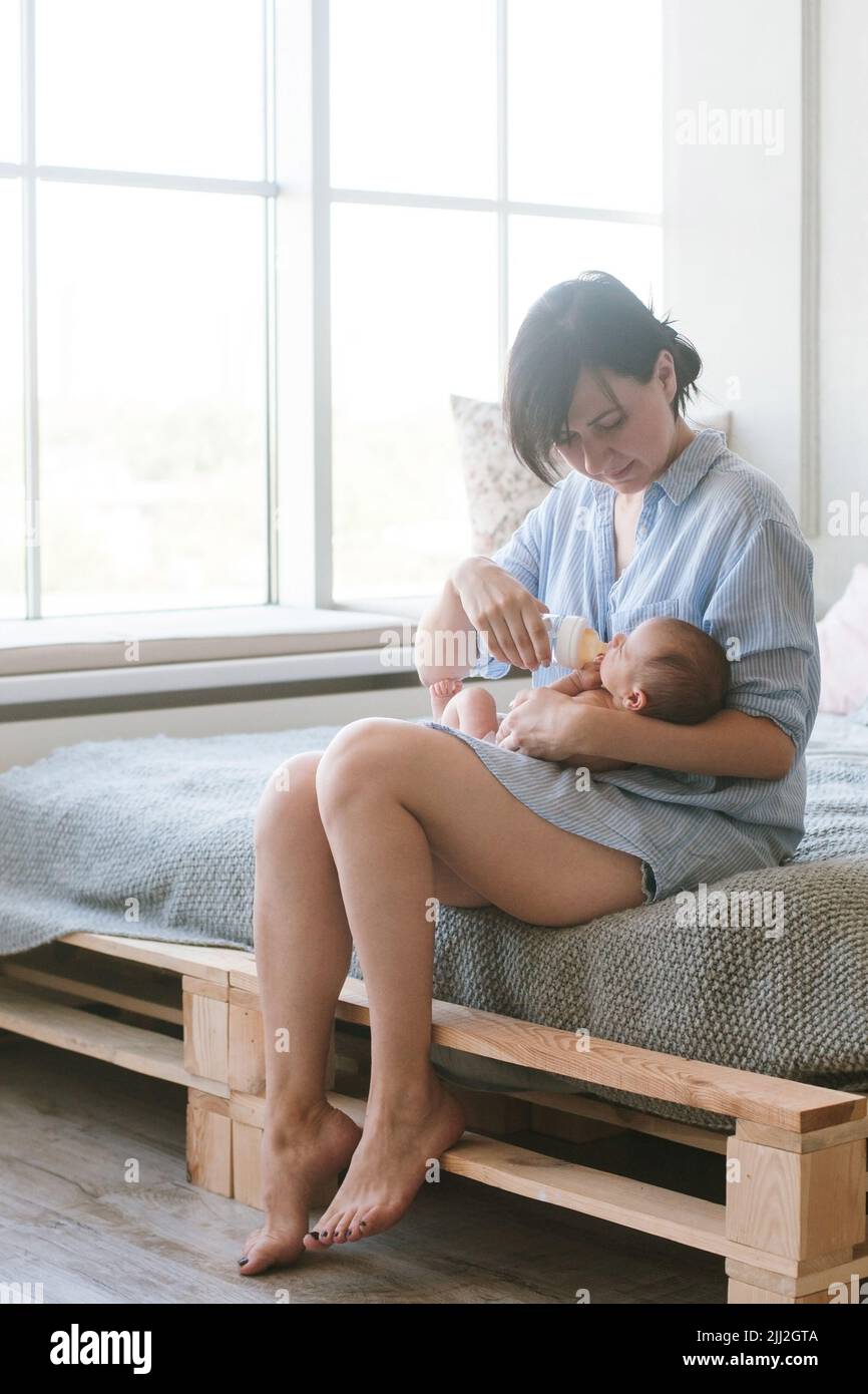 allattare il neonato con una miscela in un biberon Foto Stock