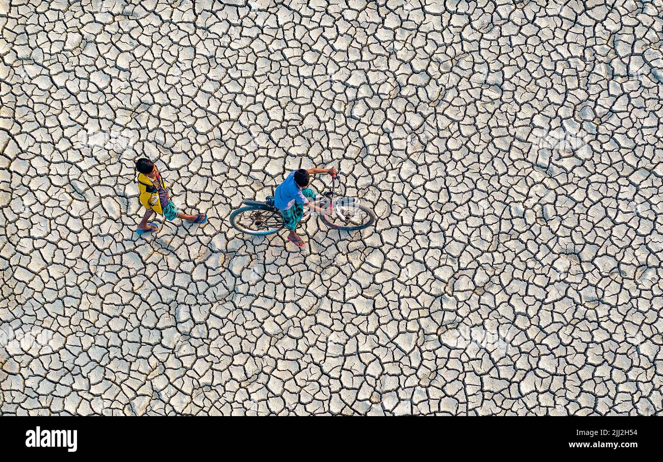 Terreni agricoli asciutti incrinati sotto il sole rovente, simbolo della siccità, dei cambiamenti climatici, delle carenze del raccolto, del suolo arido, ondata di caldo, riscaldamento globale, crisi agricola Foto Stock