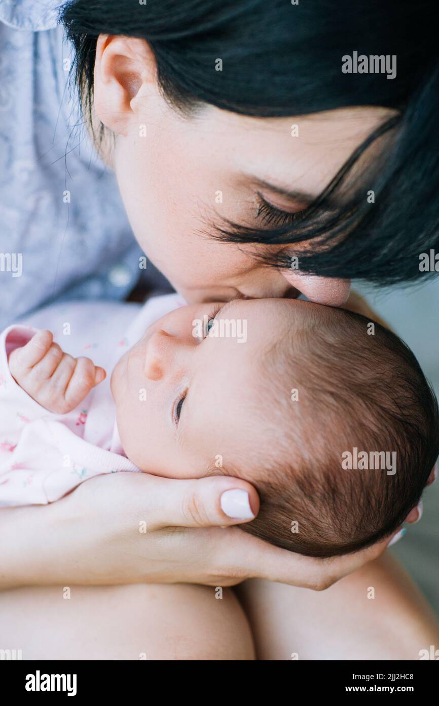 mamma bacia delicatamente il suo neonato Foto Stock