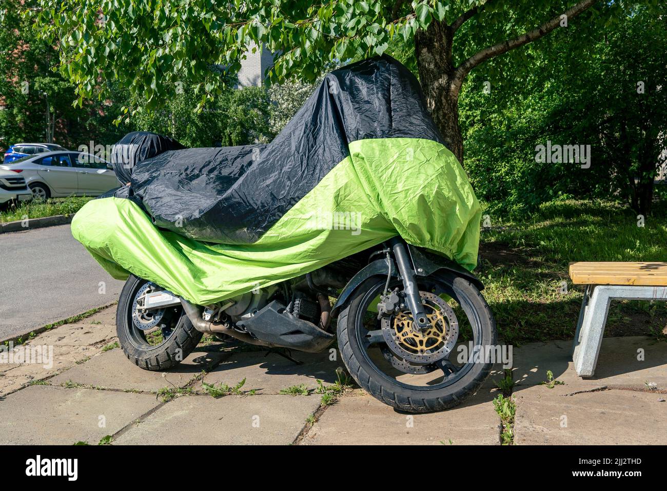 motocicletta nel parcheggio nel cortile coperto da una copertura per la pioggia Foto Stock