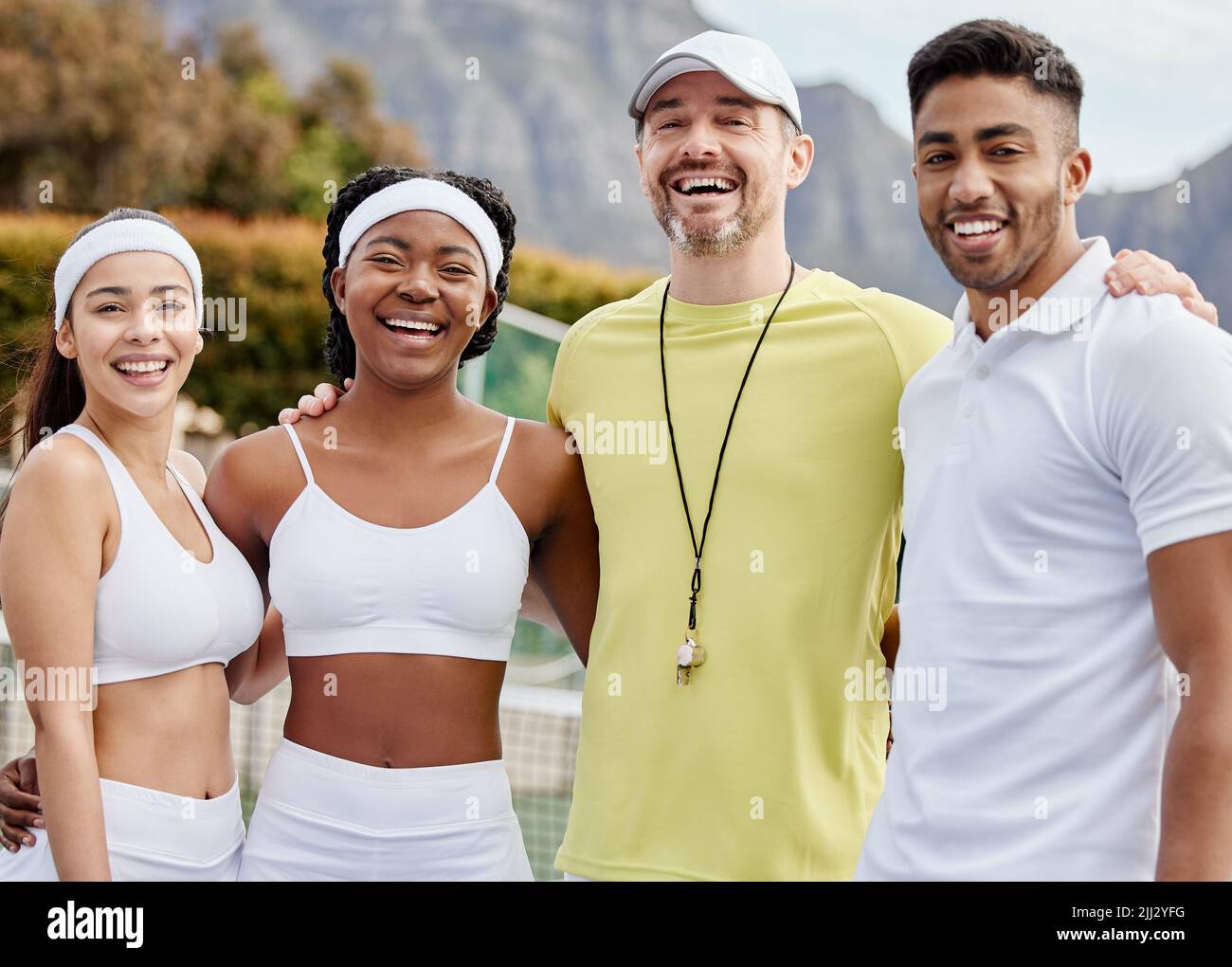 Quando lavoriamo insieme, vinciamo. Ritratto corto di tre giovani giocatori di tennis e il loro allenatore in piedi fuori sul campo. Foto Stock
