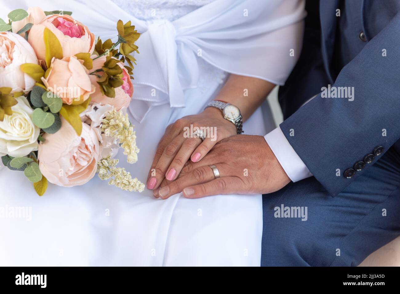 La mano della sposa sulla parte superiore delle spose per mostrare gli anelli di cerimonia nuziale si scambiò durante la cerimonia di matrimonio. Foto Stock