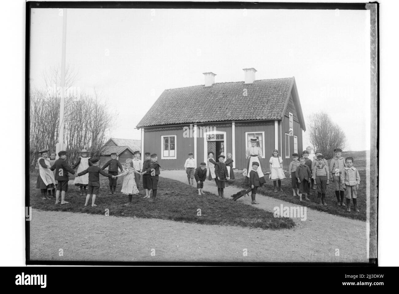 Scuola di Lillkyrka, scolari con insegnanti. Edificio scolastico sullo sfondo. Sig.ra Mina Nyholm Foto Stock