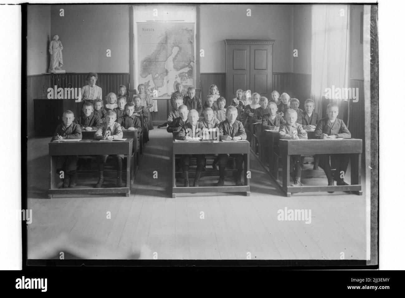 Sköllersta scuola, aule interne, 24 scolari seduti in panchine e insegnanti. L'insegnante E. Harberg Foto Stock