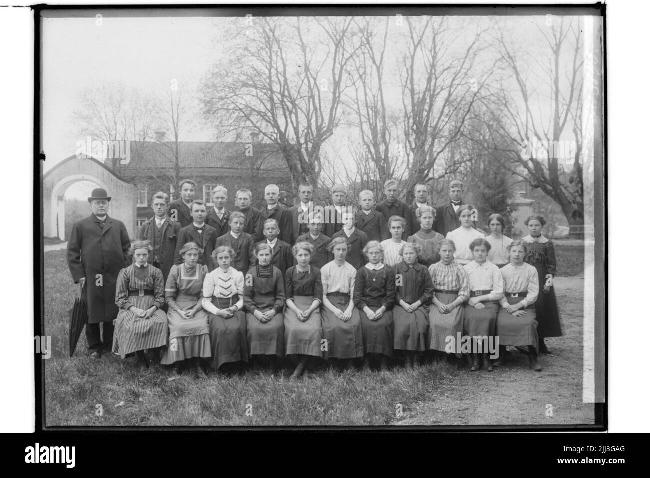 Confirmants, 32 bambini di lettura e un edificio residenziale prete.Thalings. Foto Stock