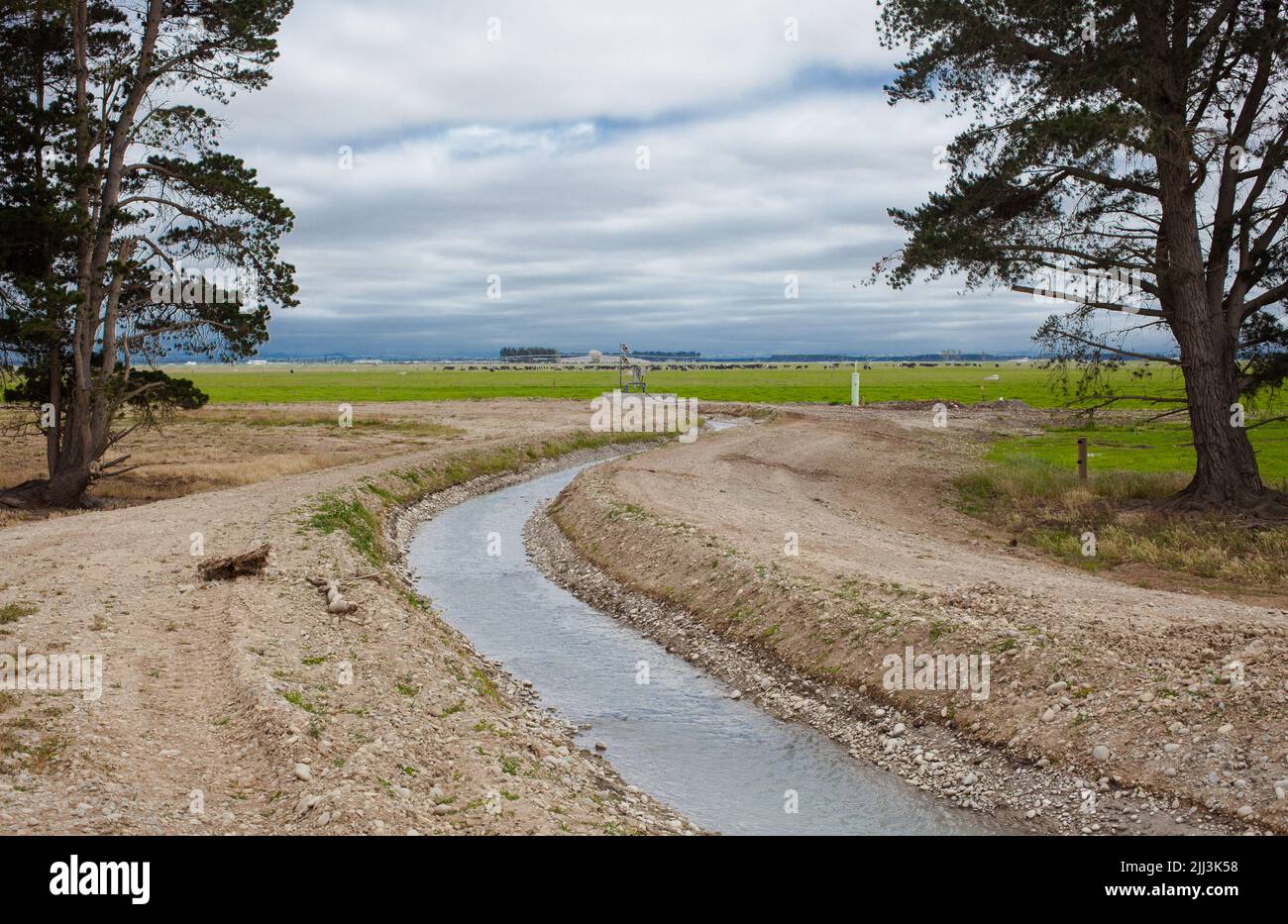 Center-Pivot Irrigation: Terreno agricolo irrigato, Canterbury Nord, Isola del Sud Nuova Zelanda. Gara di irrigazione che riempie nuova diga di deposito. Foto Stock